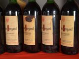 four bottles of wine are lined up on a table