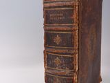 an old book sitting on top of a table next to a white wall