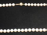 un collier de perles blanches sur fond noir