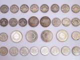 an image of a collection of silver coins on a white surface