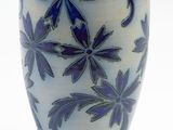 a blue and white vase sitting on a white surface