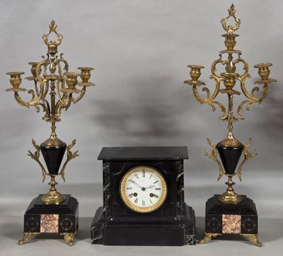 three black and gold clocks sitting next to each other