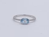 a white gold ring with a blue topaz stone surrounded by diamonds
