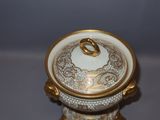 a white and gold bowl with a gold ring on it