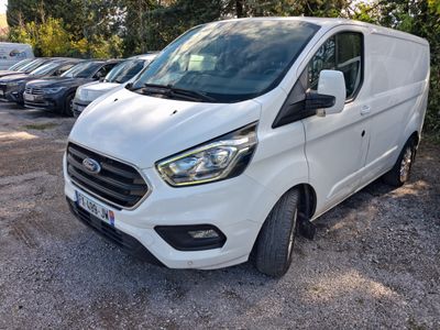 La fourgonnette Ford Transit blanche est garée sur un parking.
