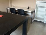 une table noire sur laquelle est collé un autocollant rouge, dans une pièce