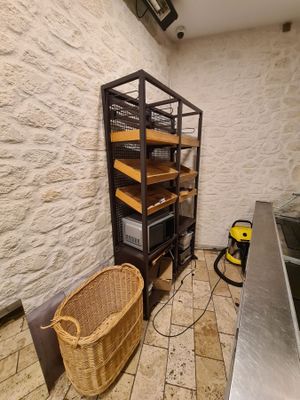 a kitchen with a sink and a shelf with shelves