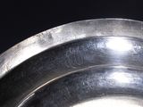 a close up of a metal bowl with a black background