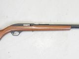 un fusil de chasse au canon en bois posé sur une surface blanche
