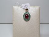 un gros plan d'un collier orné d'une pierre rouge