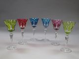 plusieurs verres à vin de couleurs différentes sont alignés