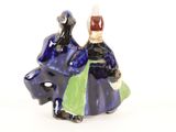 a figurine of a man and a woman riding on a horse