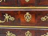 a dresser that has a lot of gold decorations on it