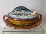 a bowl with a fish on it sitting on a glass shelf