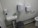 une salle de bains équipée de toilettes, d'un lavabo et d'un sèche-mains