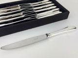 silverware in a black box on a white table with a knife and fork