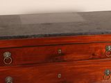 a small wooden chest of drawers with a marble top