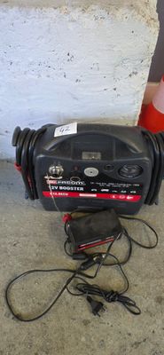 a black blower sitting on the ground next to a red cone