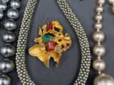 many different necklaces and bracelets that are on a table