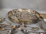 a lot of silver spoons and silverware on the table