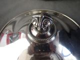 a silver plate with a face on it on a table