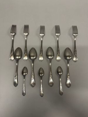 six fourchettes et cuillères sont disposées en rangée sur une table