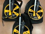 three yellow and black wheels on a brown floor with a black bag