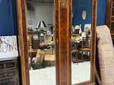 a large wooden cabinet with a mirror on top of it