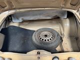 a tire in the trunk of a car with a flat tire