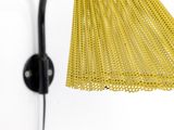 a close up of a wall light with a yellow shade on it