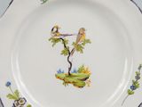 a plate with a bird on it on a table