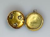 two gold lockes sitting on top of each other on a white surface