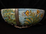 a blue bowl with yellow flowers on it on a black background