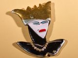 a picture of a pin with a woman ' s face on it