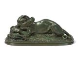 bronze statue of a lion laying on a rock with a snake in its mouth