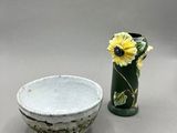 a small bowl and a vase with a flower in it