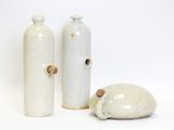 three white vases sitting next to each other on a white surface