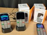 three cell phones sitting next to each other on a table