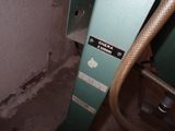 a hose attached to a green machine in a dirty room