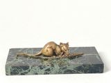 a statue of a mouse sitting on top of a marble block