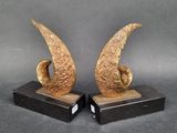 pair of bronze sculptures of a bird on a black marble base