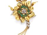 une broche en forme de fleur, sertie d'émeraudes et de diamants, signée Van Cleef
