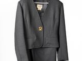 grey suit with gold buttons on a hanger on a white background