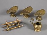 three antique brass objects on a gray surface