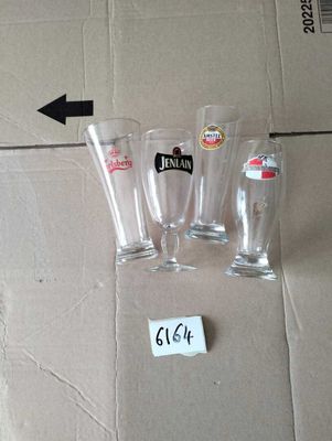 three empty beer glasses sitting on the floor next to a cardboard box
