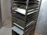 an image of a kitchen with a metal rack with trays of doughnuts on it