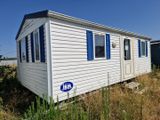 une petite maison blanche avec des volets bleus aux fenêtres