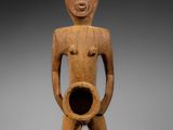 une statue en bois représentant un homme tenant un pot dans ses mains