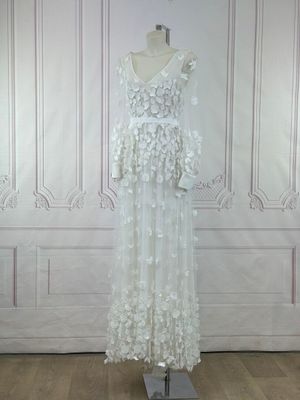 the wedding dress is on a mannequin stand in front of a wall