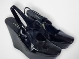 pair of black wedged shoes on a white background